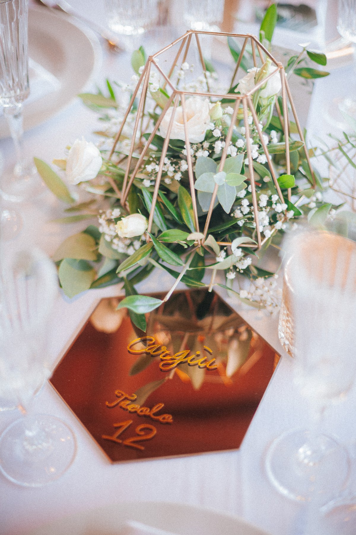 Wedding design industrial chic di Andrea e Giorgia, con tableau geometrico esagonale, segnatavolo specchiati dorati e dettagli grafici botanici.