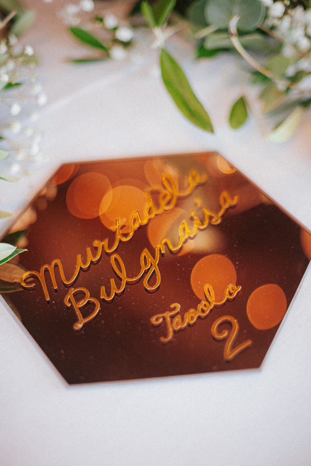 Wedding design industrial chic di Andrea e Giorgia, con tableau geometrico esagonale, segnatavolo specchiati dorati e dettagli grafici botanici.