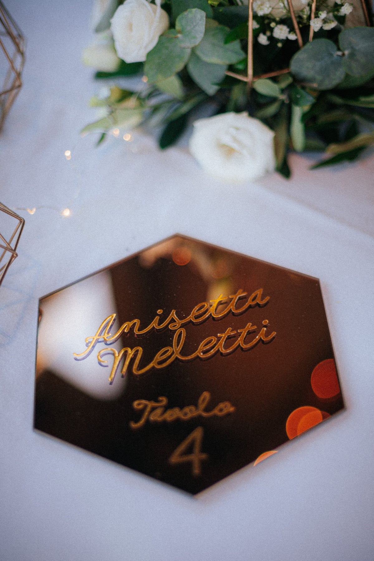 Wedding design industrial chic di Andrea e Giorgia, con tableau geometrico esagonale, segnatavolo specchiati dorati e dettagli grafici botanici.